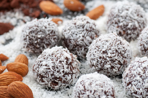 Coconut Bliss Balls with almonds in the foreground